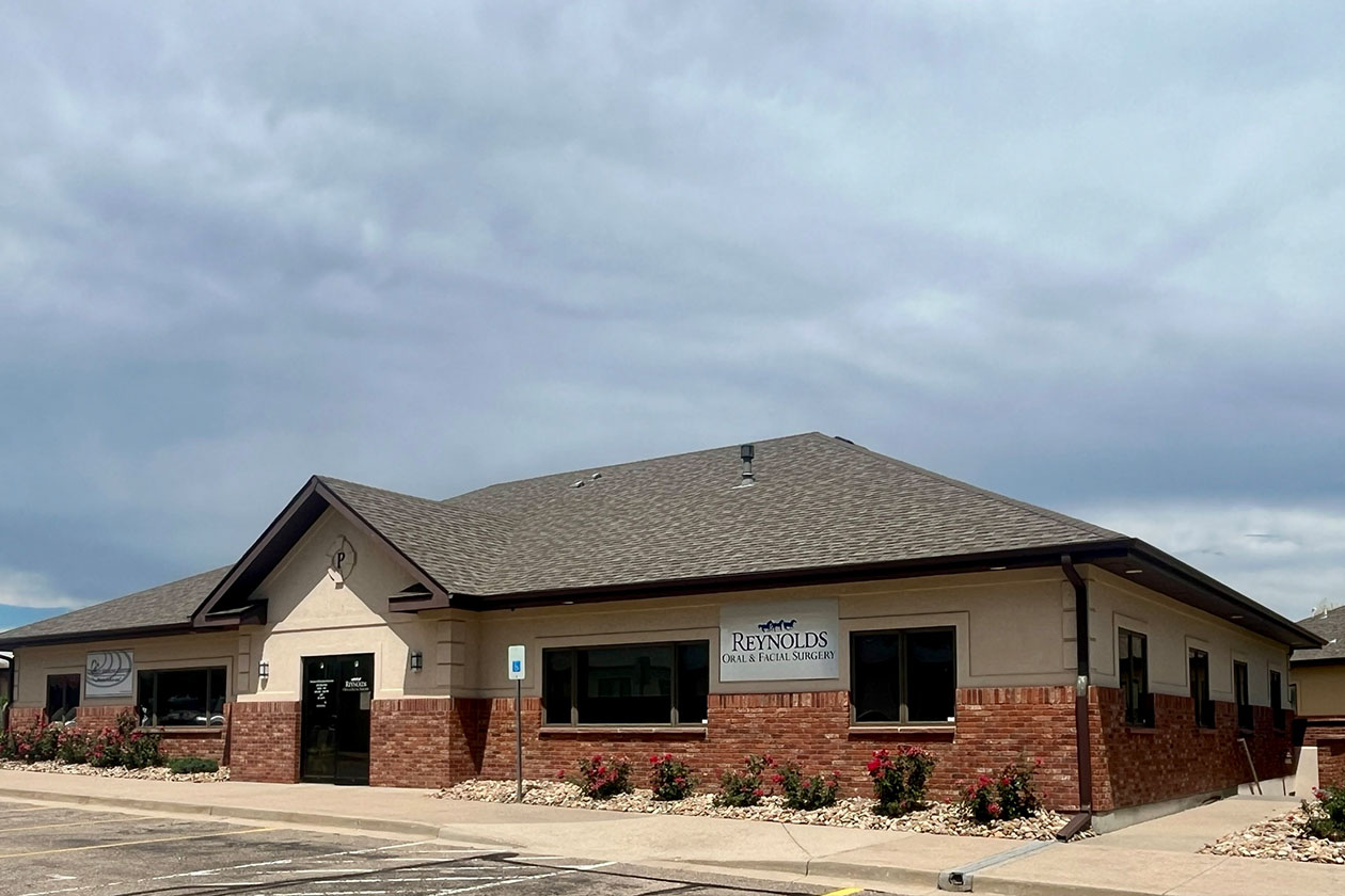 The image shows a single-story building with a sign that reads  CUSTOM BUILDING  on its exterior, which appears to be an office or commercial space.